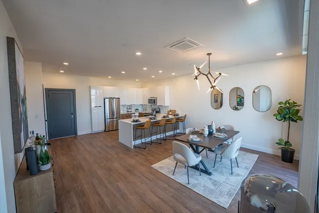 a living room with furniture kitchen view and a chandelier