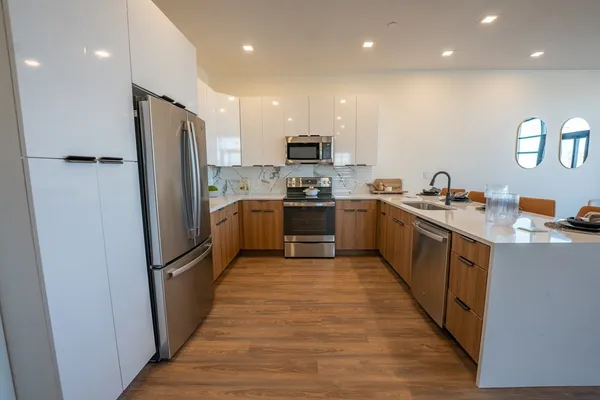 a large kitchen with stainless steel appliances lots of counter space and a sink