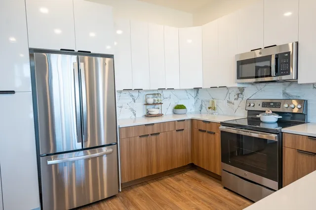 a kitchen with stainless steel appliances a refrigerator sink and microwave