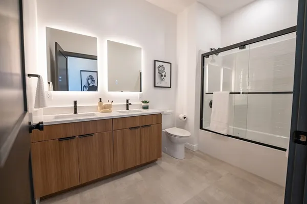 a bathroom with a double vanity sink mirror and toilet