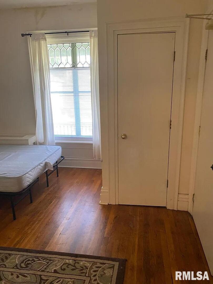 415 East 7th Street Davenport, IA 52803 - Photo 2 of 7 an empty room with wooden floor and windows