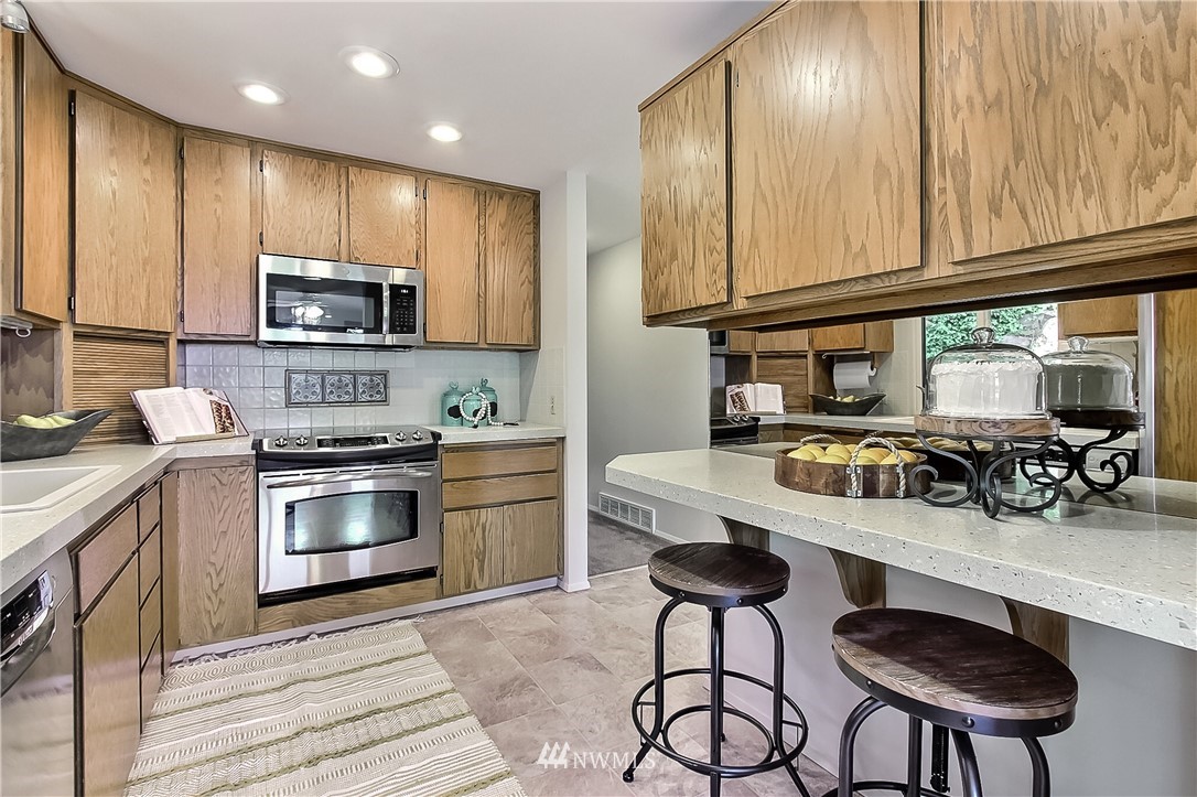 4032 Southwest Myrtle Street Seattle, WA 98136 - Photo 8 of 23 a kitchen with stainless steel appliances a stove a sink cabinets and a microwave