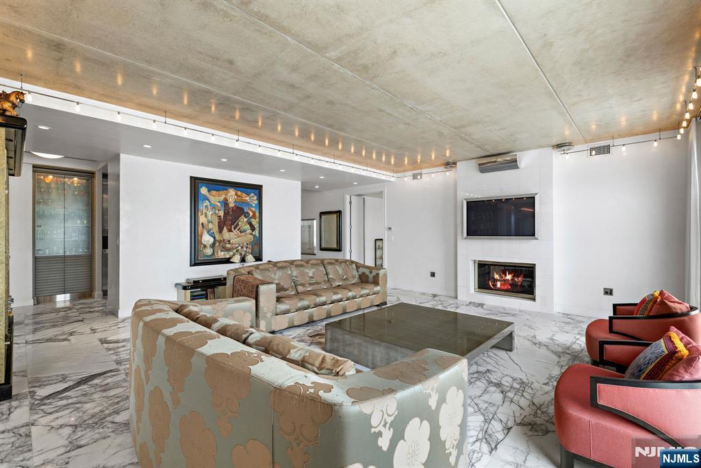 1055 River Road, Unit PH 8 Edgewater, NJ 07020 - Photo 11 of 30 a living room with furniture and a fireplace