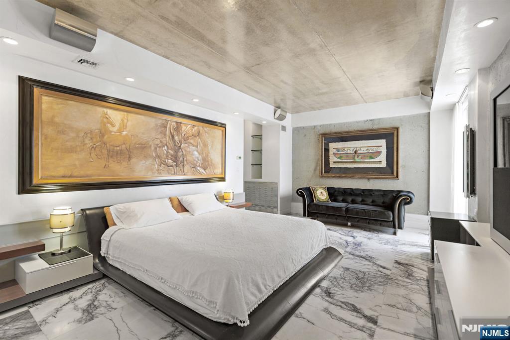 1055 River Road, Unit PH 8 Edgewater, NJ 07020 - Photo 13 of 30 a bedroom with a bed a table and painting on the wall