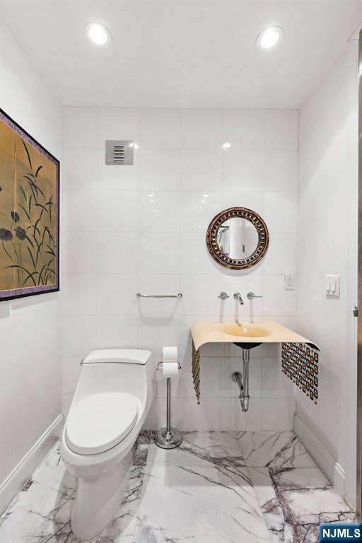 1055 River Road, Unit PH 8 Edgewater, NJ 07020 - Photo 21 of 30 a bathroom with a sink a toilet and a mirror