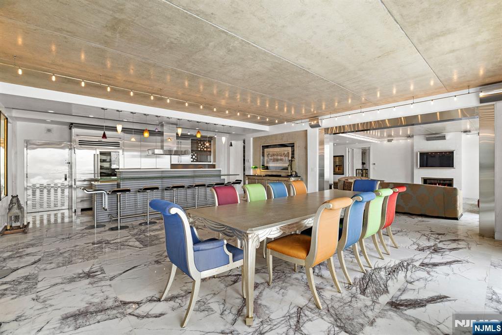 1055 River Road, Unit PH 8 Edgewater, NJ 07020 - Photo 4 of 30 a dining area with furniture and a kitchen view