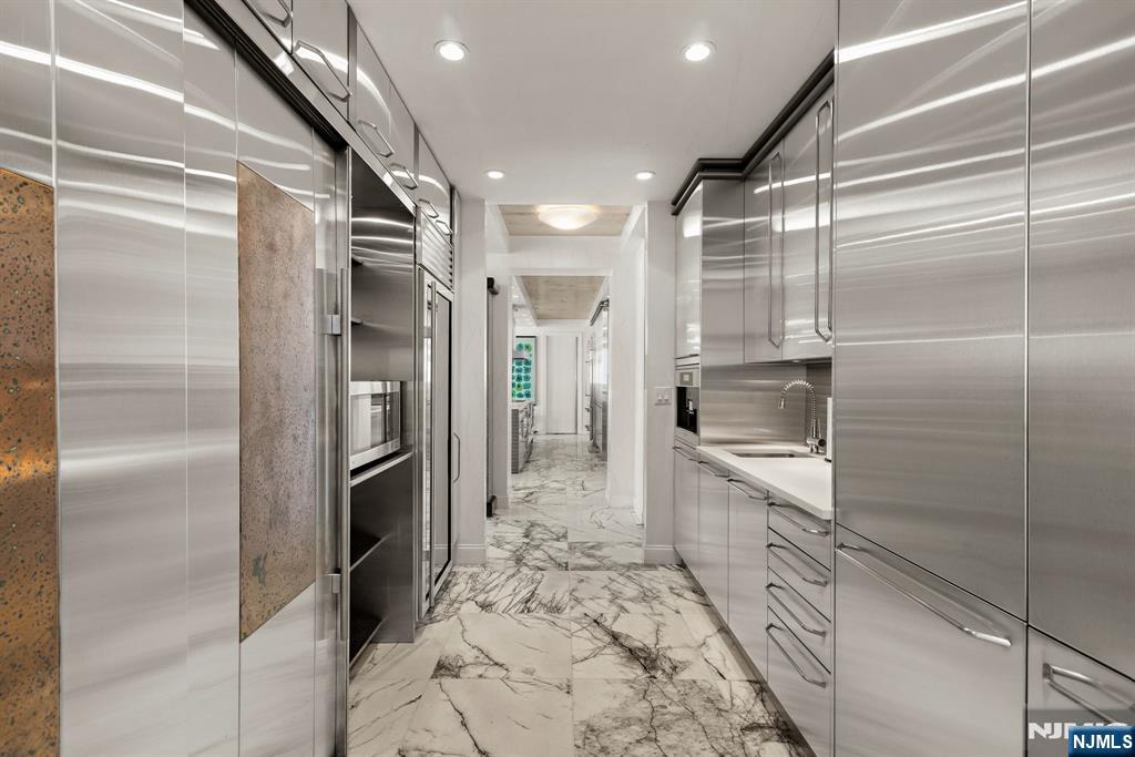 1055 River Road, Unit PH 8 Edgewater, NJ 07020 - Photo 8 of 30 a kitchen with granite countertop a refrigerator and a sink