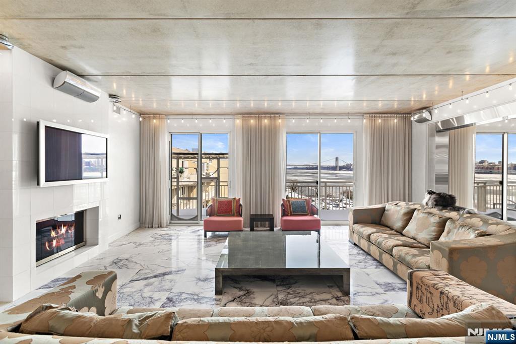 1055 River Road, Unit PH 8 Edgewater, NJ 07020 - Photo 9 of 30 a living room with furniture and a fireplace