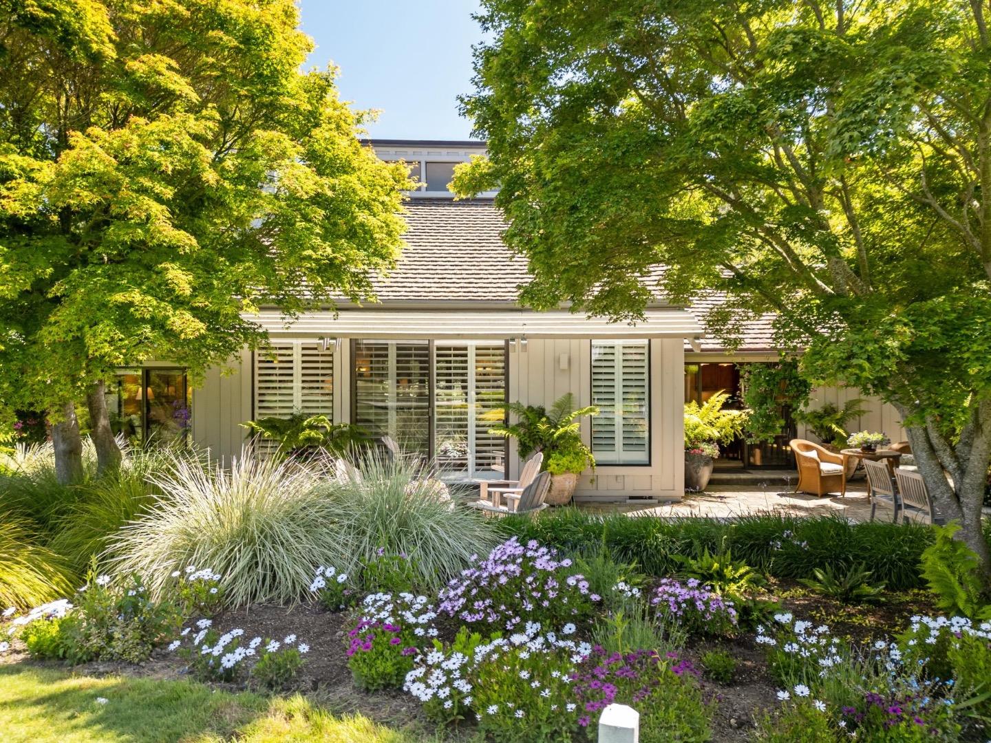 a front view of a house with a garden and sitting area
