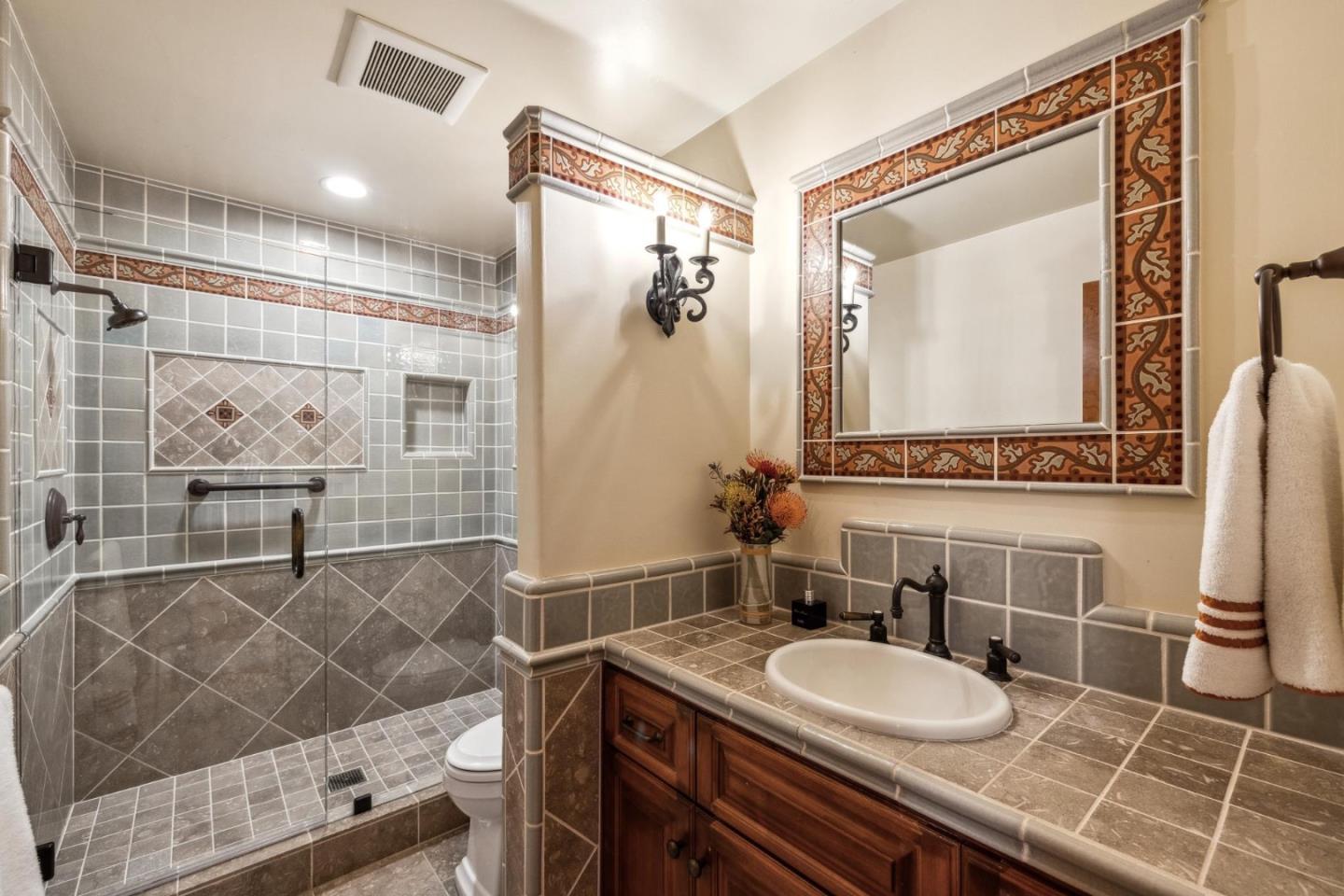 9546 Maple Court Carmel, CA 93923 - Photo 14 of 36 a bathroom with a granite countertop sink a mirror and a shower