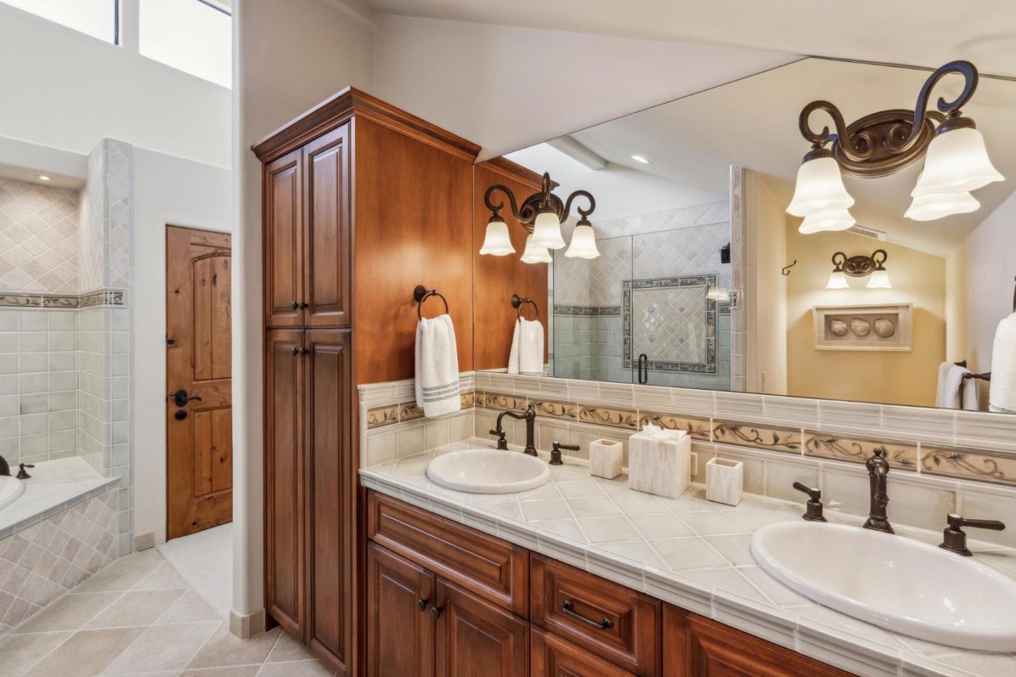9546 Maple Court Carmel, CA 93923 - Photo 21 of 36 a bathroom with a sink double vanity granite tub shower and a mirror