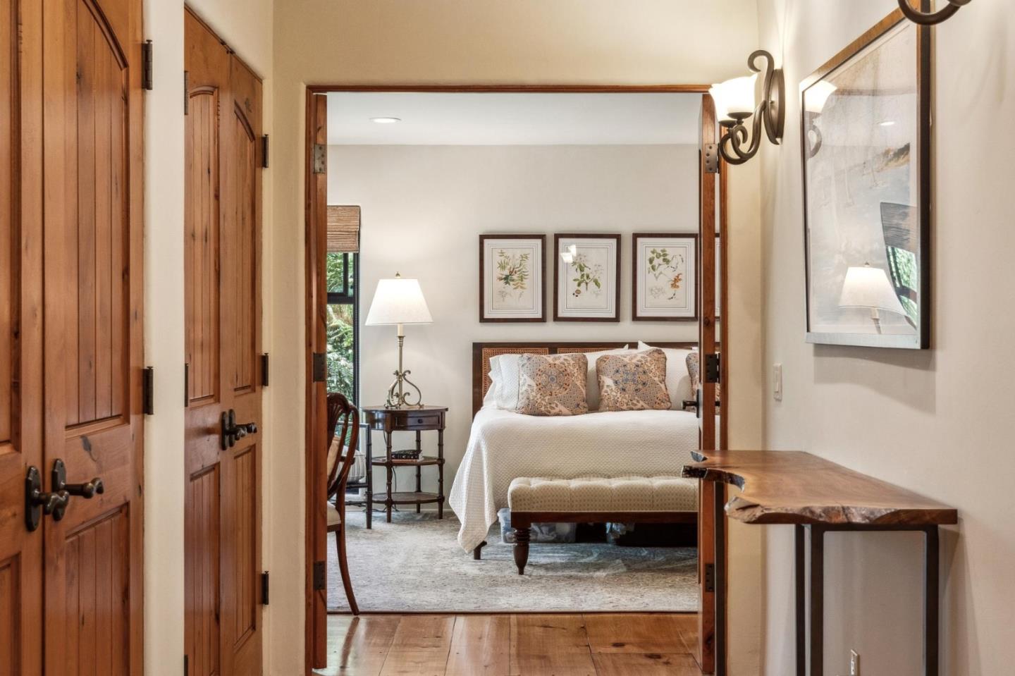 9546 Maple Court Carmel, CA 93923 - Photo 8 of 36 a bedroom with a bed a table and painting on the wall