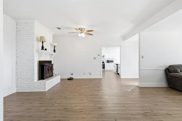 a view of empty room with wooden floor and fireplace
