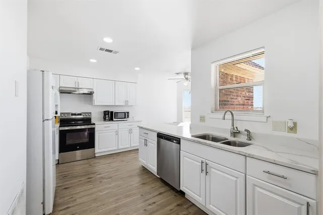 a kitchen with a white cabinets and window