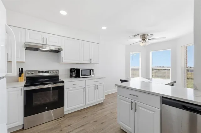 a kitchen with cabinets stainless steel appliances and a sink