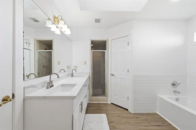 a bathroom with a double vanity sink a large mirror and shower