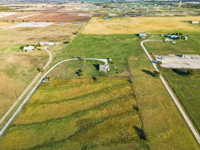 a view of yard with grass & bench