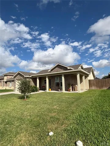 a view of a house with a big yard and large trees