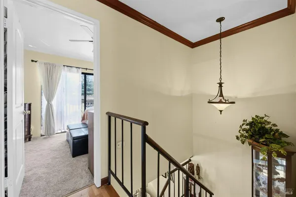 a view of a hallway with wooden floor and stairs