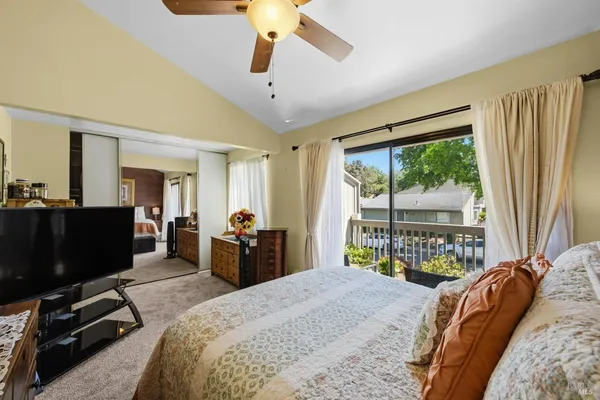 a bedroom with a bed and a flat tv screen on the dresser