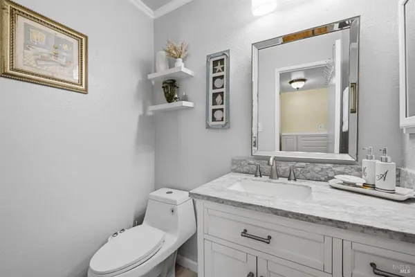 a bathroom with a granite countertop toilet sink and mirror