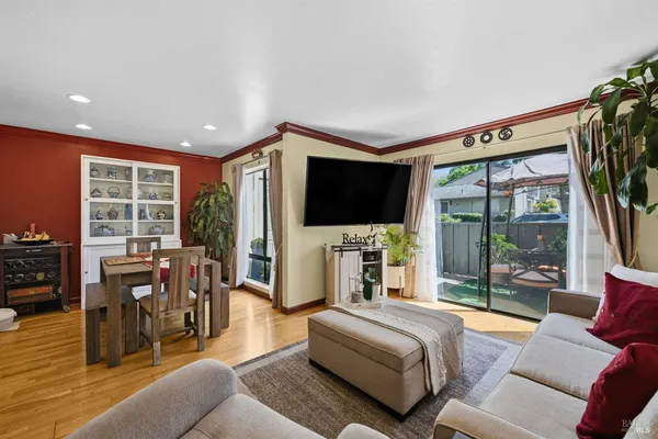 a living room with furniture a flat screen tv and a floor to ceiling window