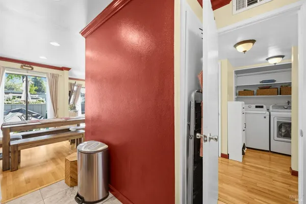 a view of a hallway with wooden floor and windows