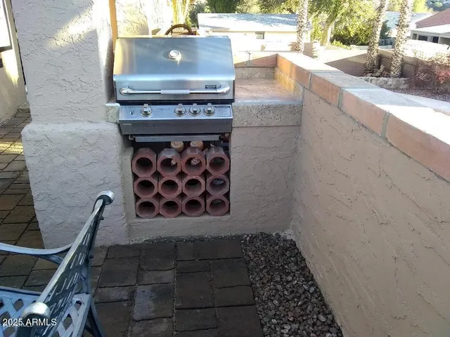 a view of a patio with table and chairs under an umbrella