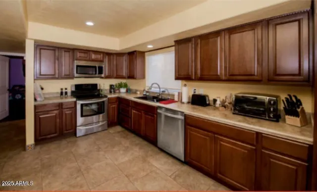 a kitchen with stainless steel appliances granite countertop wooden cabinets a stove top oven a sink and dishwasher