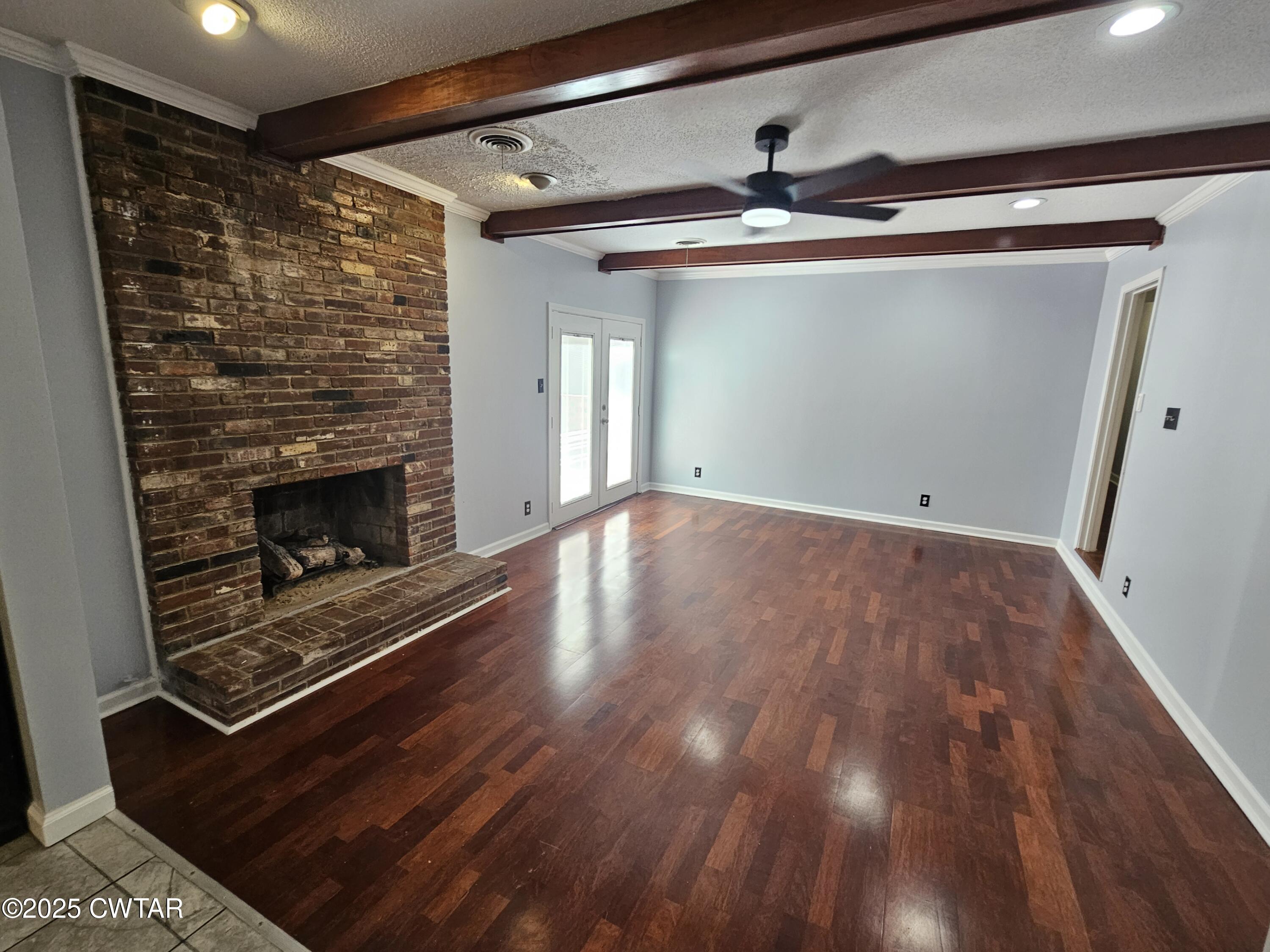 116 Chickering Road Jackson, TN 38305 - Photo 3 of 20 a view of empty room with wooden floor and fireplace