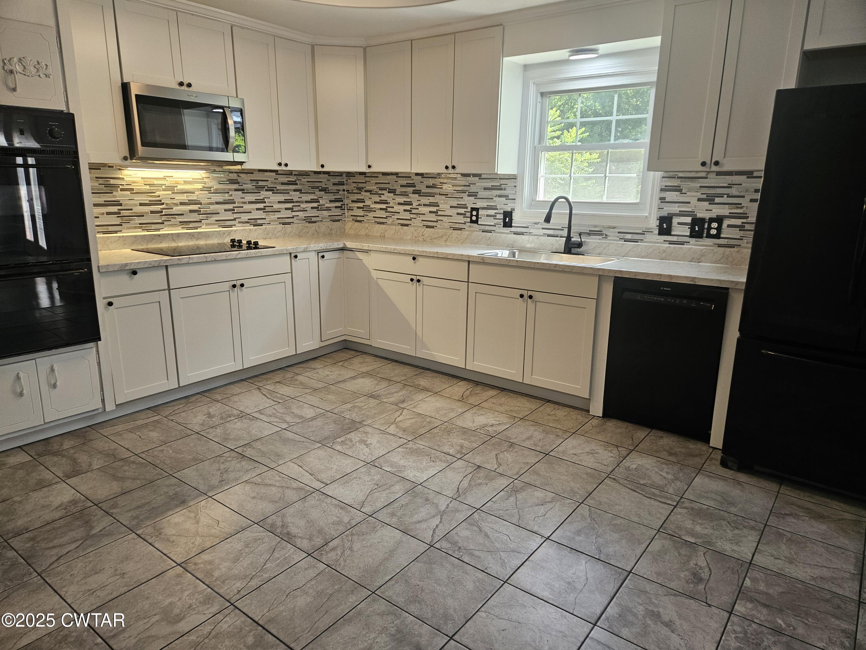 116 Chickering Road Jackson, TN 38305 - Photo 7 of 20 a kitchen with a sink window and cabinets