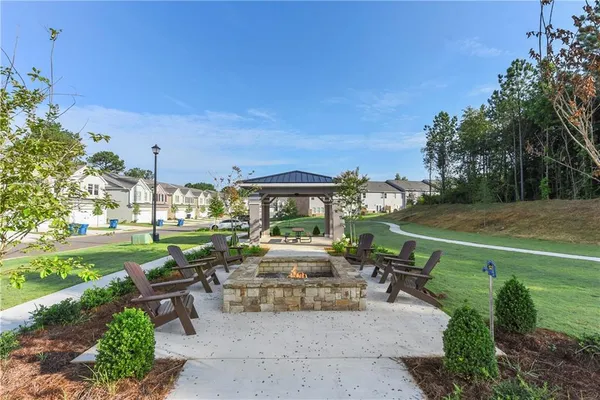 a view of a patio with couches plants and large tree