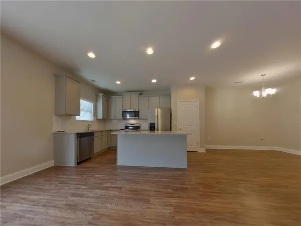 a view of kitchen with kitchen island stainless steel appliances counter top and living room