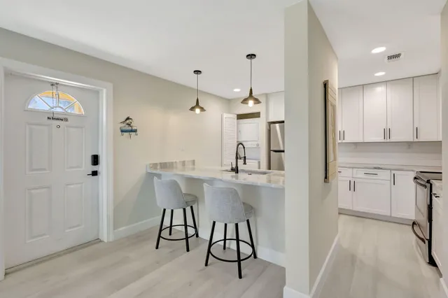 a kitchen with stainless steel appliances granite countertop a sink and a refrigerator