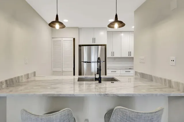 a kitchen with white cabinets and appliances