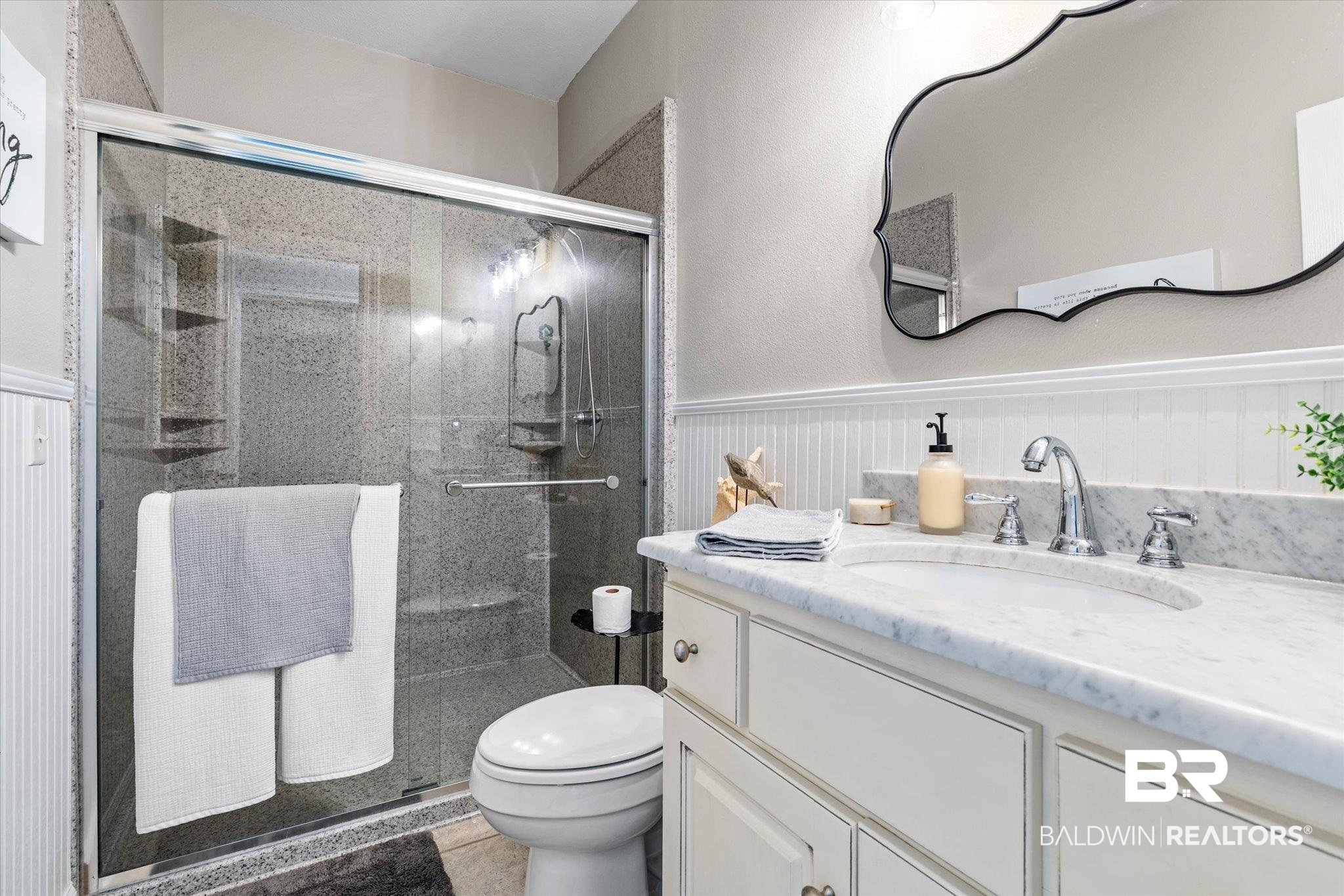 4947 Look Rook Road Orange Beach, AL 36561 - Photo 15 of 24 Full bath featuring toilet, a stall shower, vanity, and wainscoting