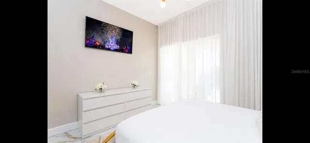 a bedroom with a bed and a painting on the wall