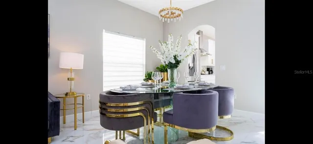 a dining room with furniture and a potted plant