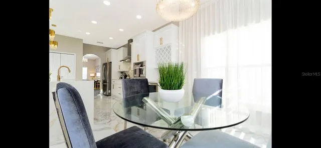 a large white kitchen with a sink and refrigerator