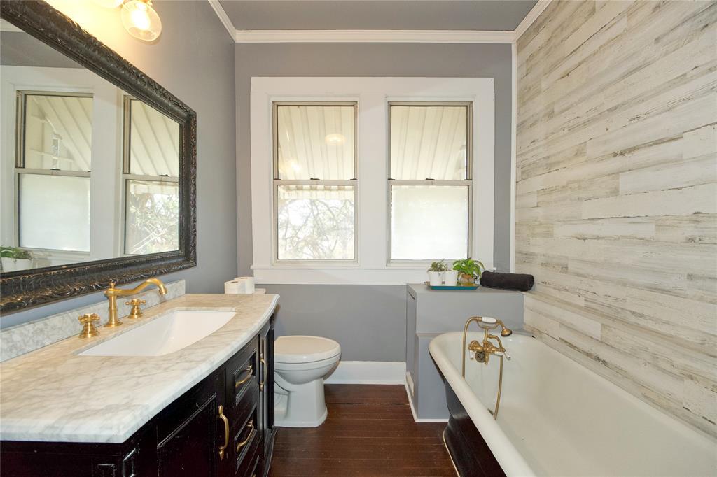 213 South Clements Street Gainesville, TX 76240 - Photo 25 of 37 a bathroom with a granite countertop sink and a bathtub