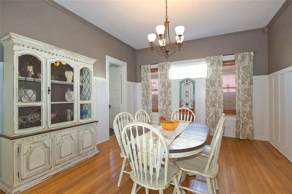 213 South Clements Street Gainesville, TX 76240 - Photo 10 of 37 a view of a dining room with furniture wooden floor and chandelier