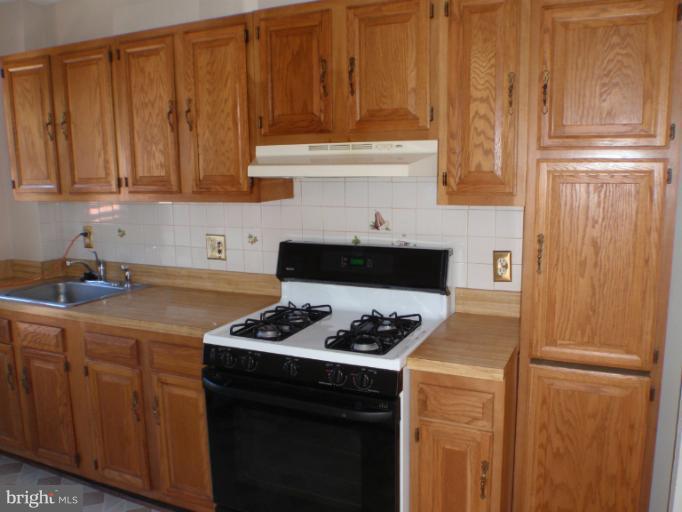 3223 13th Road South Arlington, VA 22204 - Photo 3 of 11 a kitchen with stainless steel appliances a refrigerator stove and cabinets