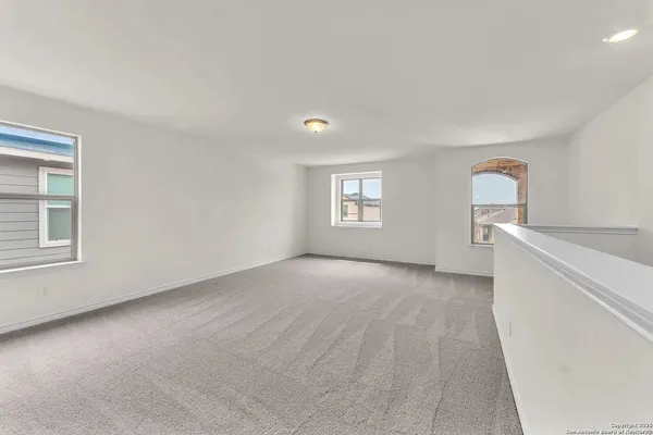 a view of empty room with window and wooden floor