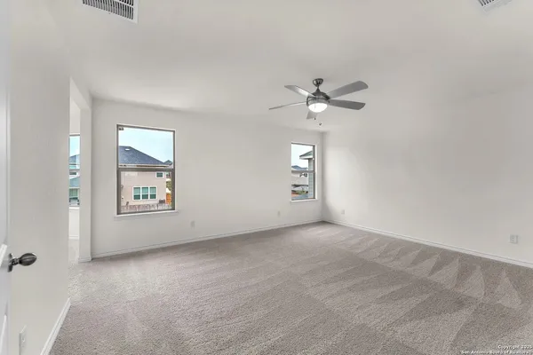 an empty room with windows and fan
