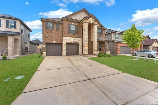 a front view of a house with a yard and trees