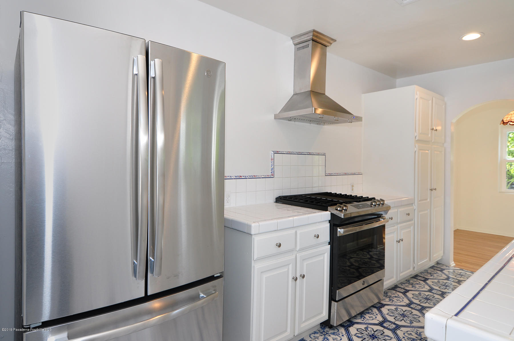 2011 Minoru Drive Altadena, CA 91001 - Photo 12 of 33 a kitchen with stainless steel appliances a refrigerator a stove and white cabinets
