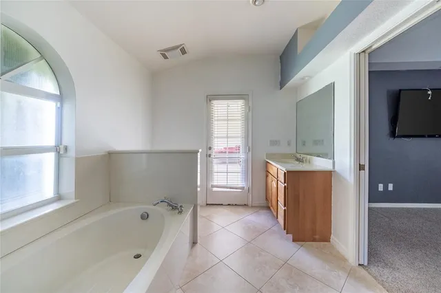 a bathroom with a bathtub sink and mirror