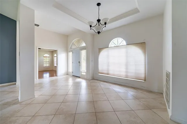 a view of a livingroom with a chandelier fan and windows