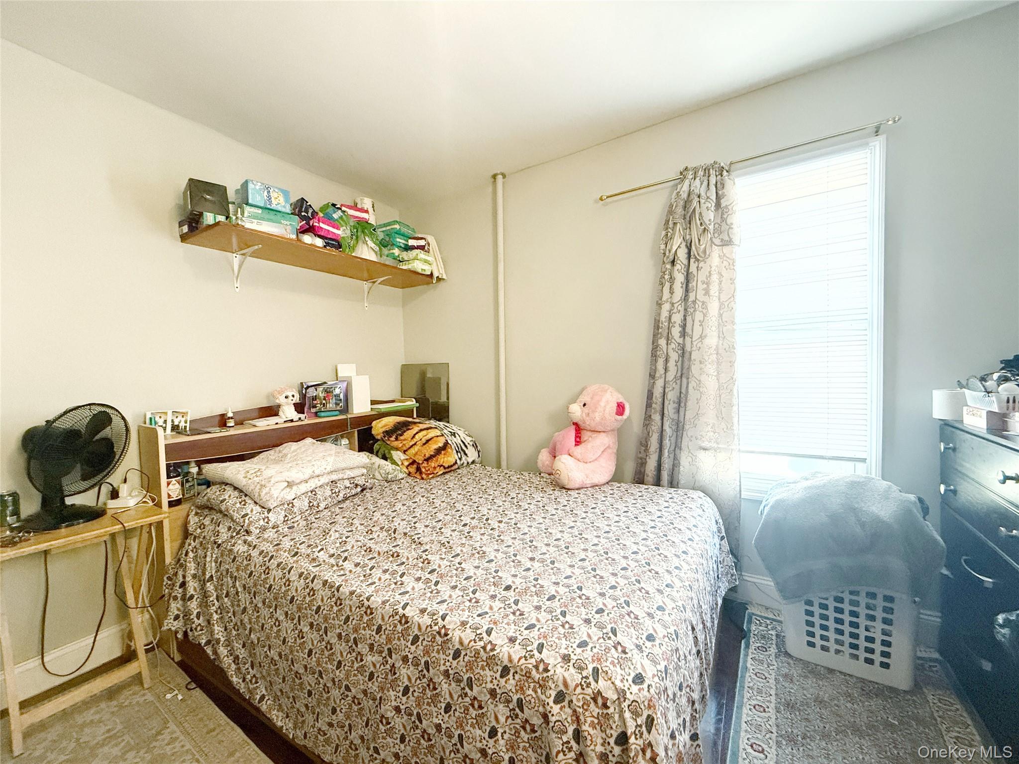 110-39 156th Street Queens, NY 11433 - Photo 16 of 27 a bedroom with a bed and a window