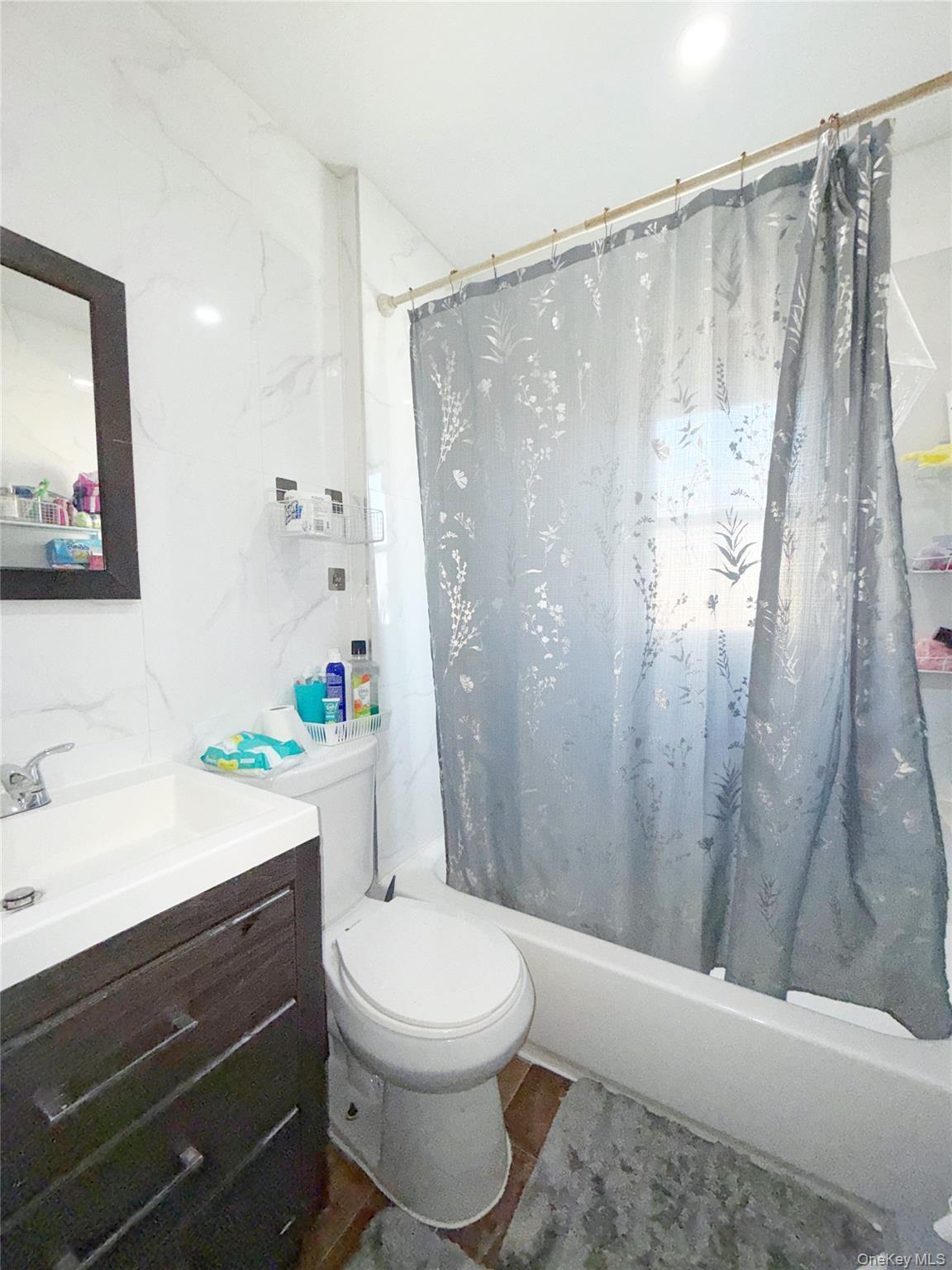 110-39 156th Street Queens, NY 11433 - Photo 10 of 27 a bathroom with a sink a toilet a shower curtain and a large mirror